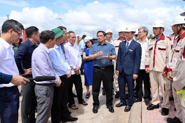 Thủ tướng trao đổi với đội ngũ kỹ sư, chủ đầu tư khi đi khảo sát dự án điện gió Hòa Bình tại xã Vĩnh Thịnh, huyện Hòa Bình, tỉnh Bạc Liêu - Ảnh: VGP