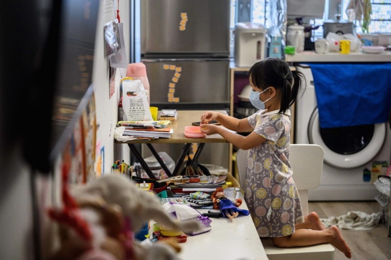 Một đứa trẻ ăn một bữa ăn nhẹ trong căn hộ studio tạm thời rộng 290 mét vuông của cô ở Hồng Kông. Bị dồn ép trong căn hộ nhỏ, gia đình cô phải vật lộn để kiếm sống ở thành phố khét tiếng bất bình đẳng (Ảnh: CNBC)