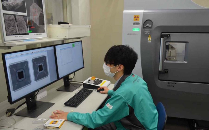 Một kỹ sư tại Oki Engineering đang kiểm tra tính xác thực của con chip (Ảnh: Nikkei Asia)