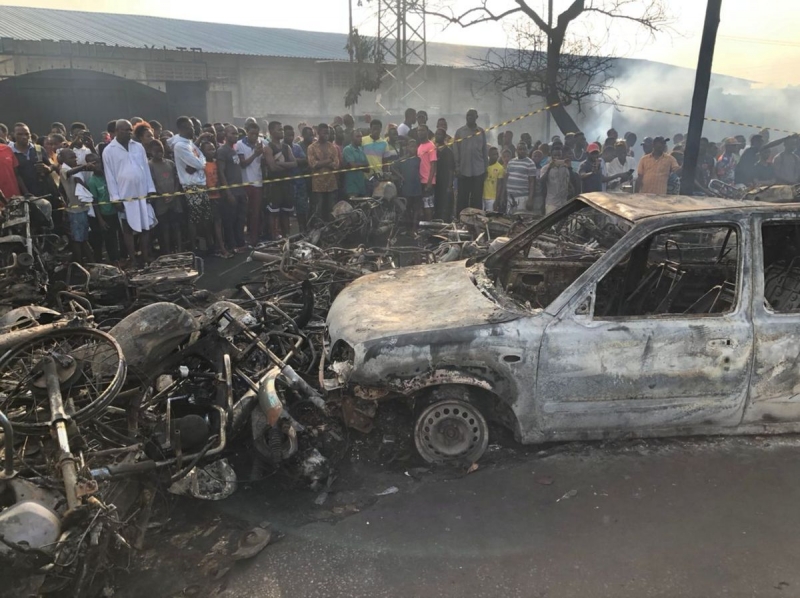 Mọi người xem ô tô và xe máy bị cháy sau vụ nổ xe bồn chở nhiên liệu ở Freetown, Sierra Leone ngày 6/11/2021