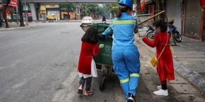 Xúc động cảnh hai bé gái nhỏ theo chân người mẹ lao công đi làm ngày lễ Tết