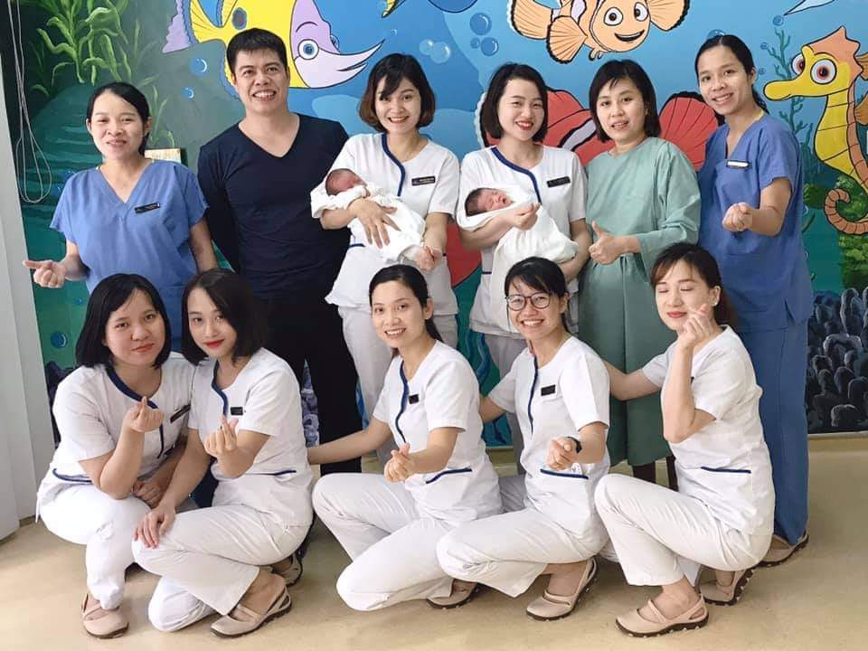 Chị Tâm (bế em bé đứng giữa) chụp ảnh cùng đồng nghiệp Khoa Sản, Bệnh viện Vinmec, Hà Nội (Ảnh: NVCC). Tắm bé ngày Tết - những câu chuyện chưa kể 1